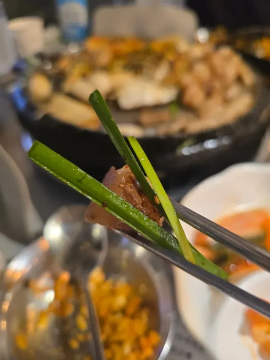 A piece of beef daechang dipped in sauce