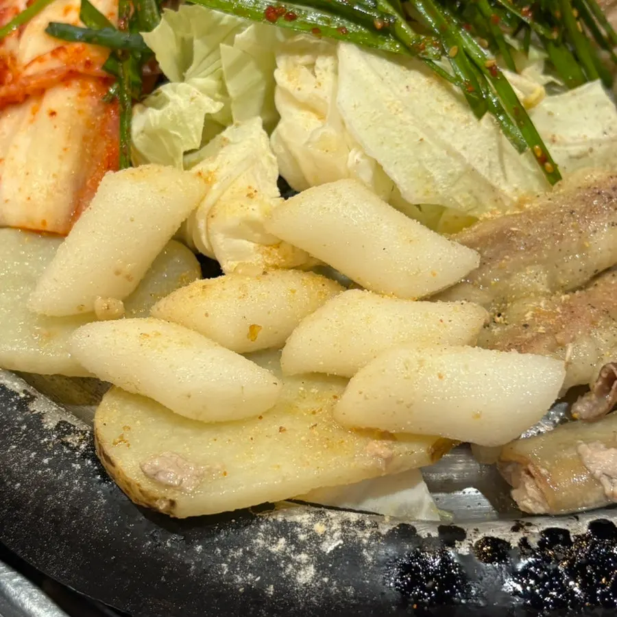 불판에서 함께 구워지는 떡과 감자, 양배추