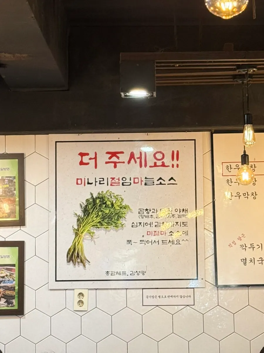 미나리절임마늘 소스에 찍은 곱창 한 점