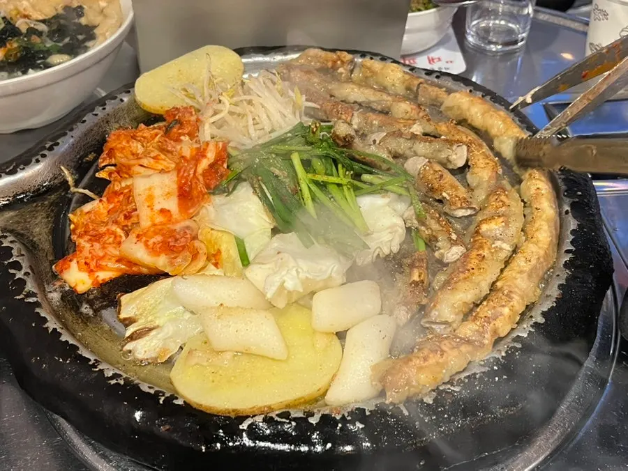 멸치국수와 곱창 철판이 함께 놓인 상