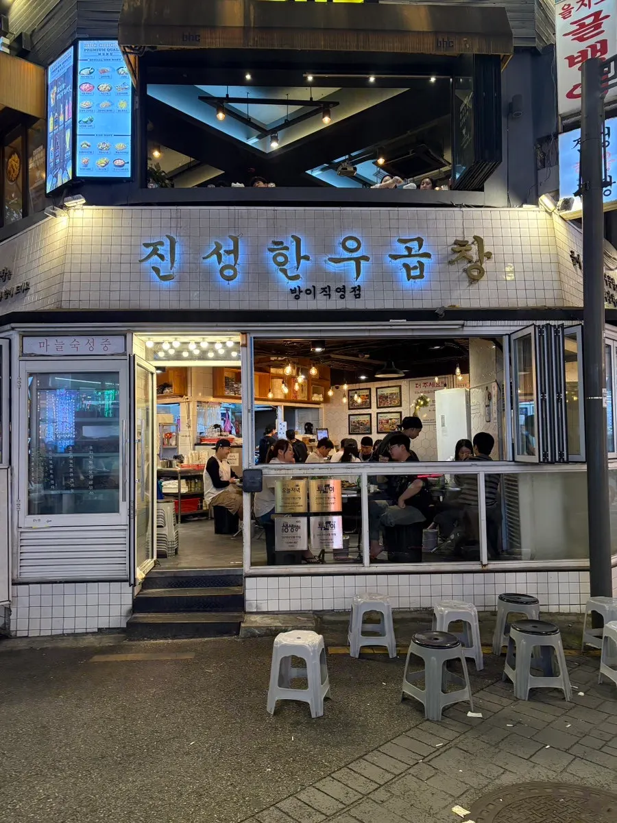 Crowded exterior of Jinseong Hanwoo Gopchang Bangi Direct Branch with waiting chairs
