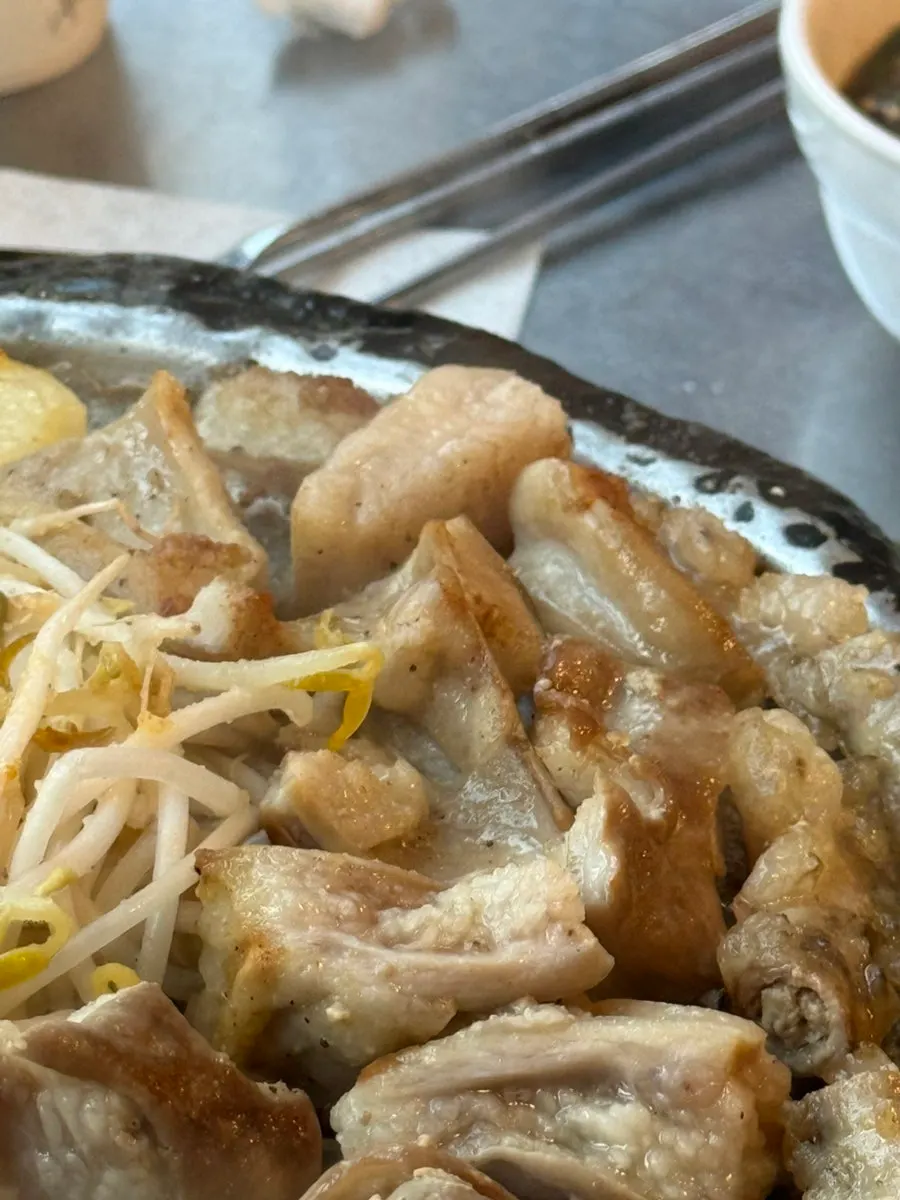 Gopchang dipped into the minari-pickle garlic sauce