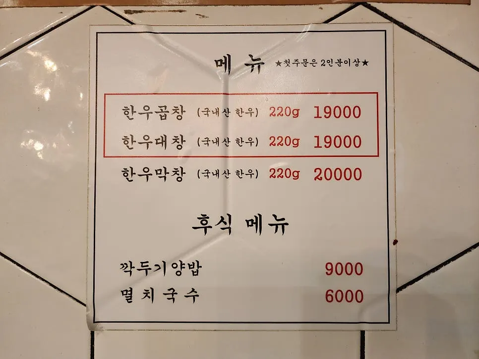 Menu board listing hanwoo gopchang and anchovy noodles