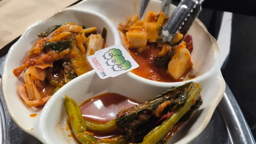Whole kimchi being cut at the table