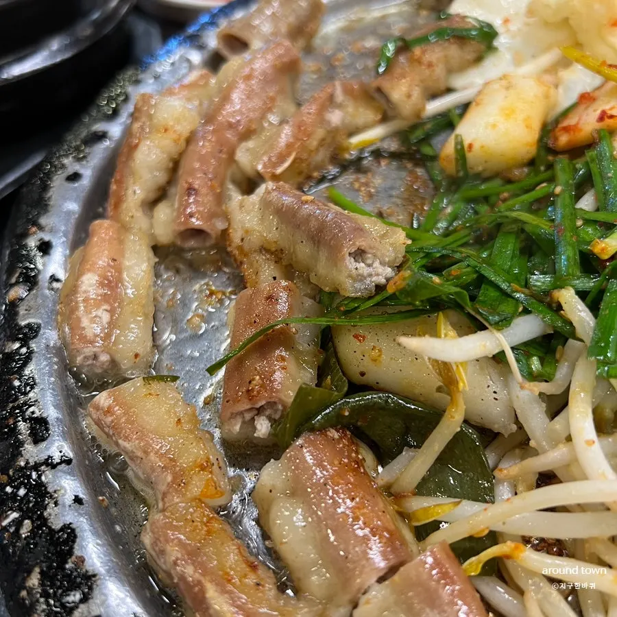 A table of gopchang and kimchi side dishes