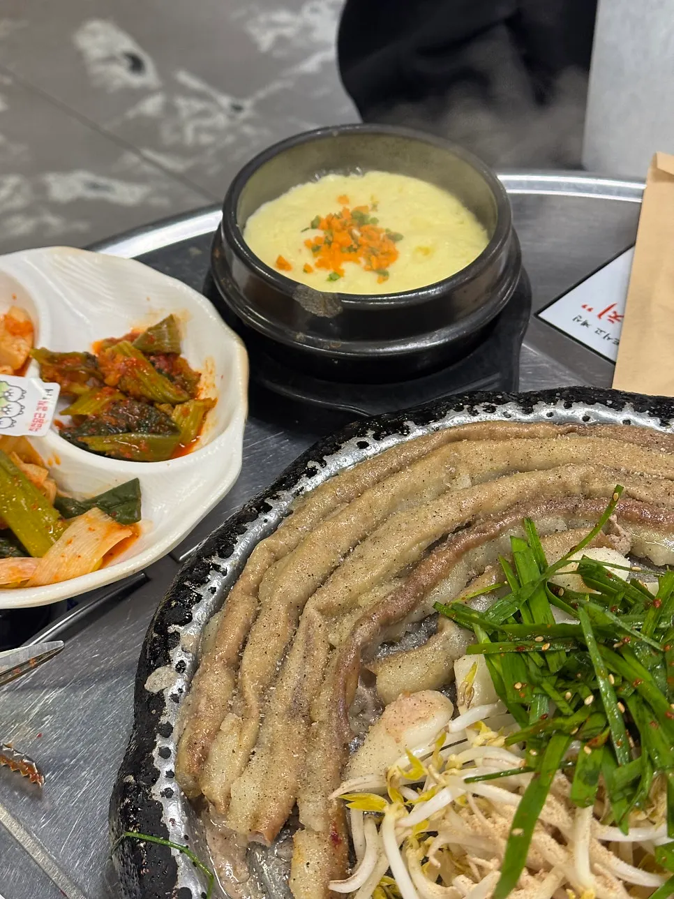 Gopchang plated with cabbage, bean sprouts, rice cakes, and potato