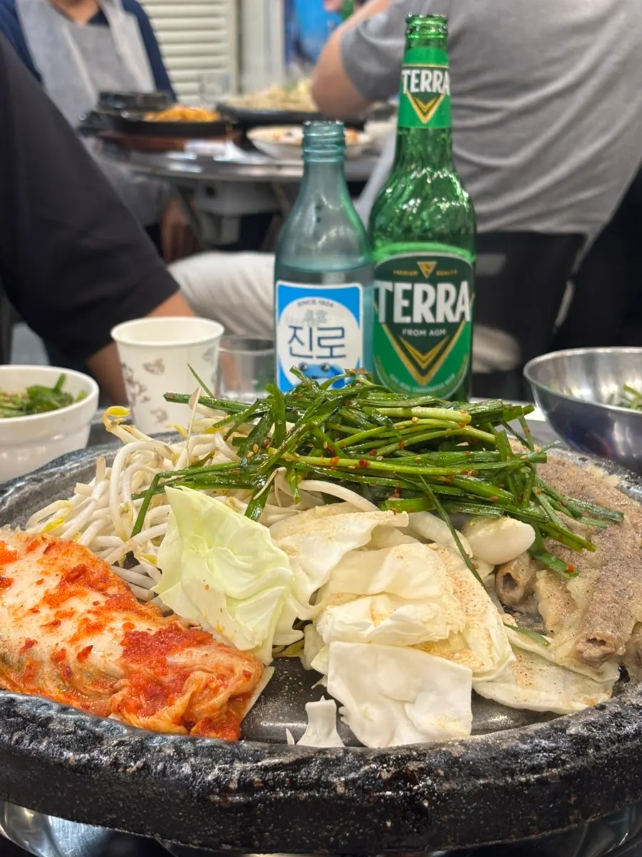 Gopchang on the grill with bean sprouts, cabbage and kimchi