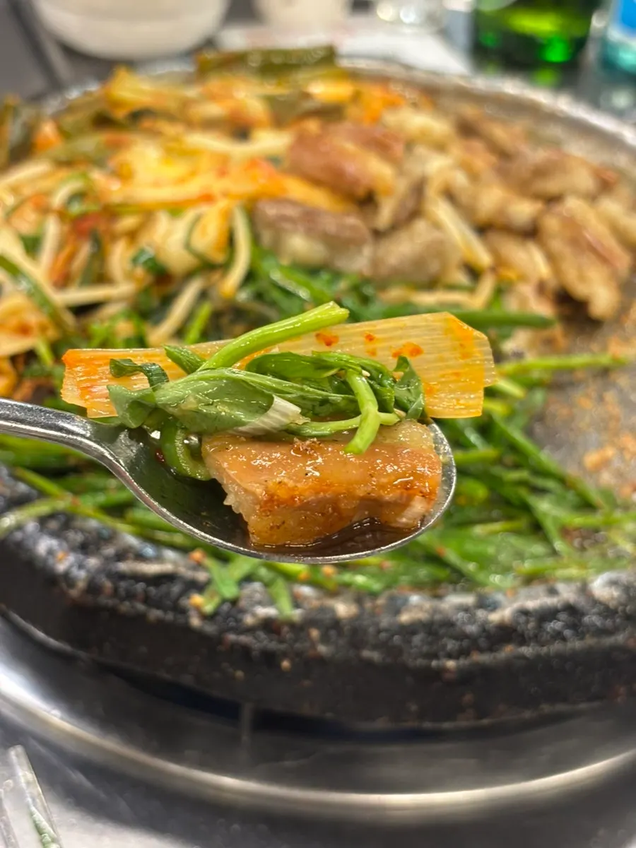 A piece of gopchang paired with chili from the pickled sauce