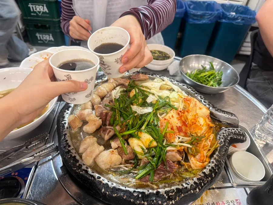 Staff grilling gopchang with an info card on the table