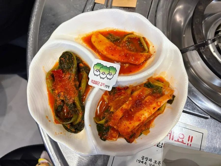 A plate of three kimchis — altari, mustard leaf, and scallion kimchi
