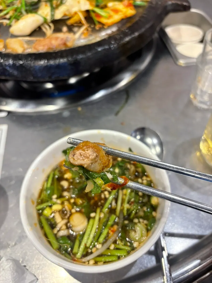 A piece of grilled beef gopchang picked up together with gat kimchi