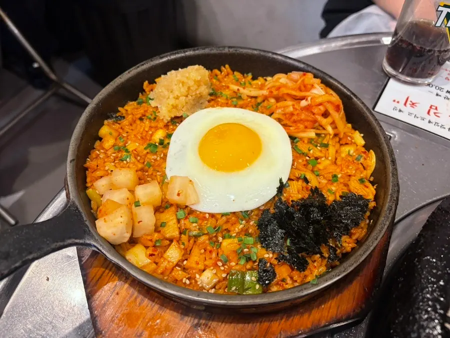 Kkakdugi fried rice topped with kkakdugi, egg, and minced garlic