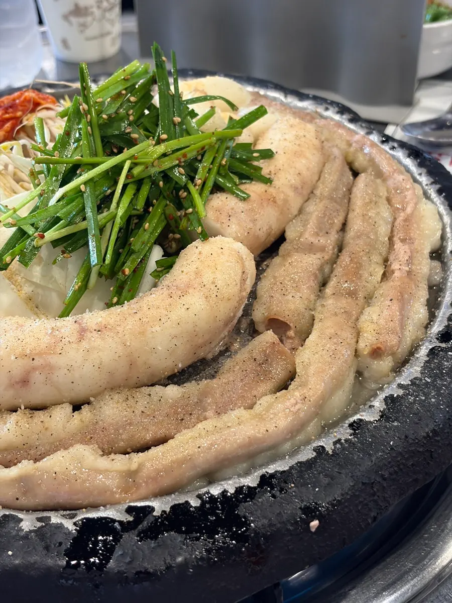 Grill topped with chives, rice cake, and onion