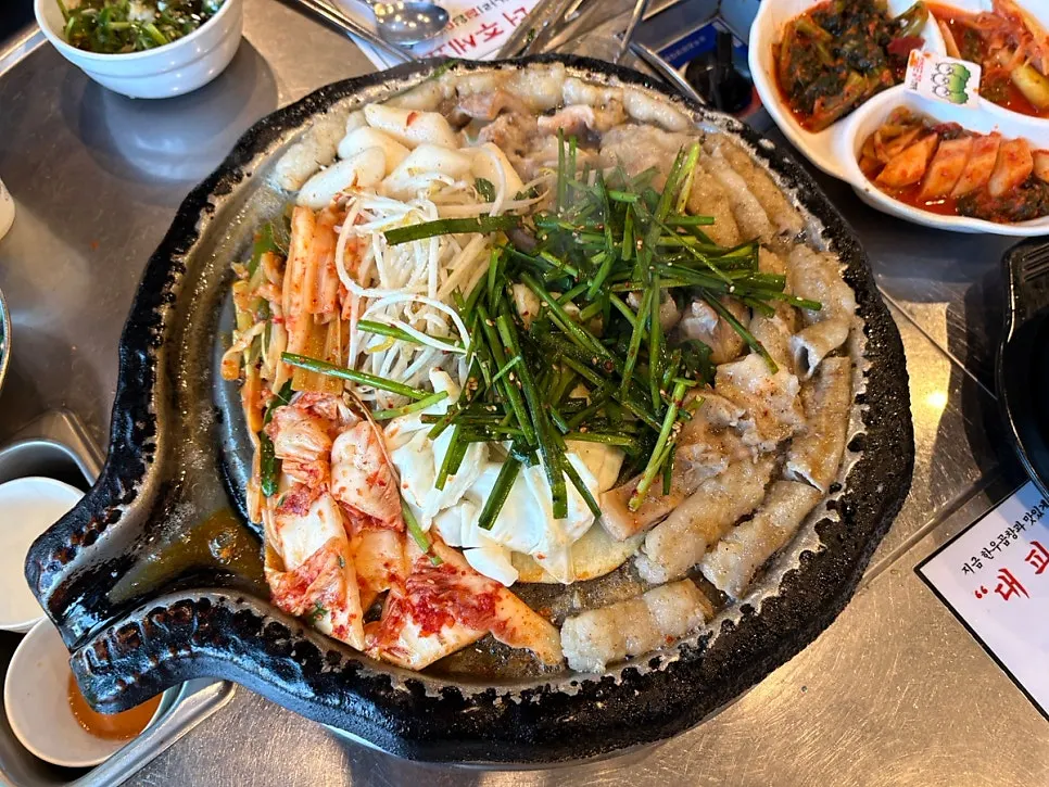 Grill with 2 servings of beef gopchang topped with vegetables and rice cake