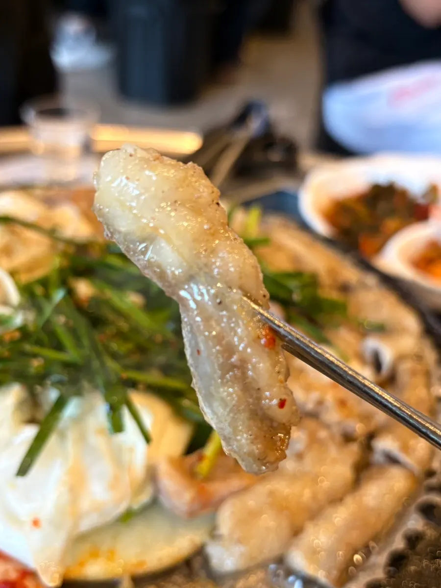 Beef gopchang grilling with kimchi piled on top
