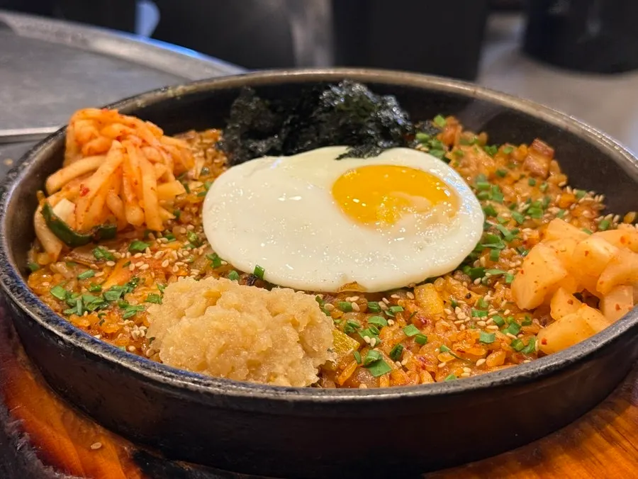 Ggakdugi jeorim maneul yangbap topped with radish salad, diced radish kimchi, seaweed flakes, and fried egg