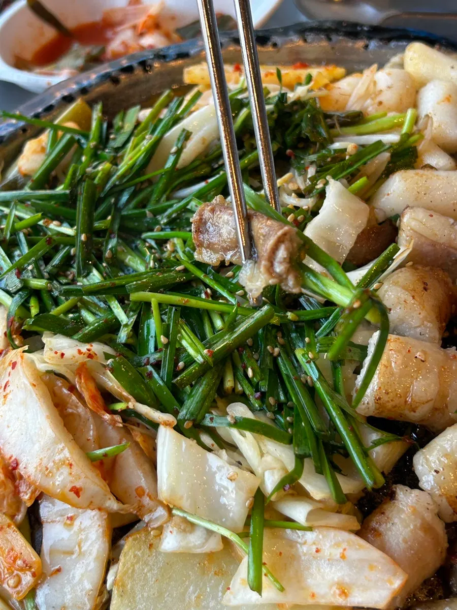沾了芹菜漬蒜醬的烤腸一塊