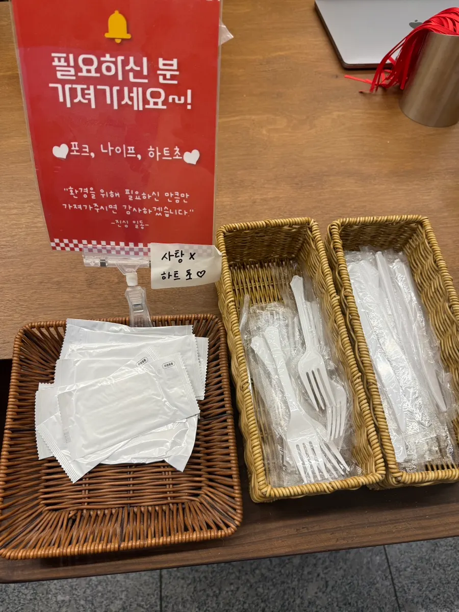 포크·나이프·물티슈와 하트 모양 초가 놓인 포장 코너