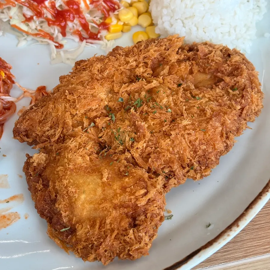 Large cutlet served alongside the noodles