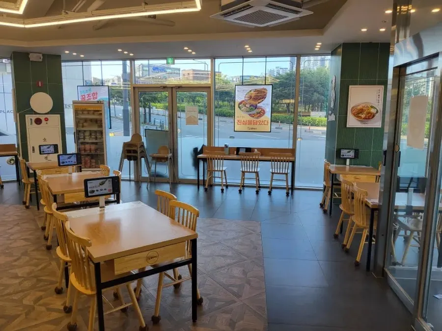Wide dining hall interior with wood-toned tables