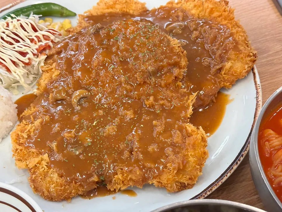 Cross-section of a wang donkatsu topped with Western-style sauce