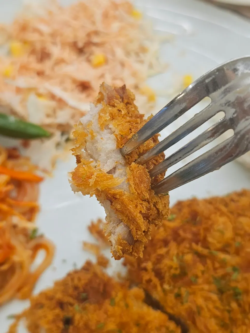 A cut piece of Jjolmyeon Katsu showing the cross-section