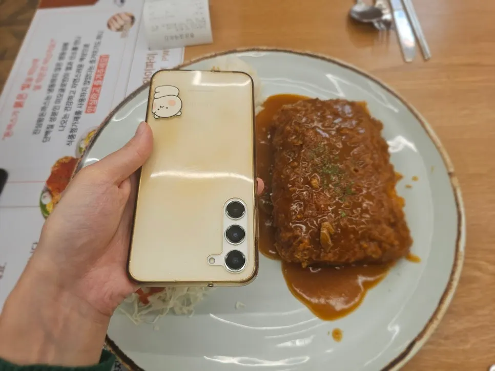 Cheese Waterfall Katsu compared in size with a phone placed next to it