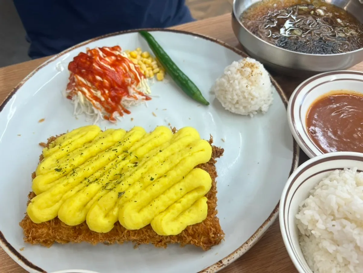 A table set with sweet potato cheese cutlet, cold soba, and a drink