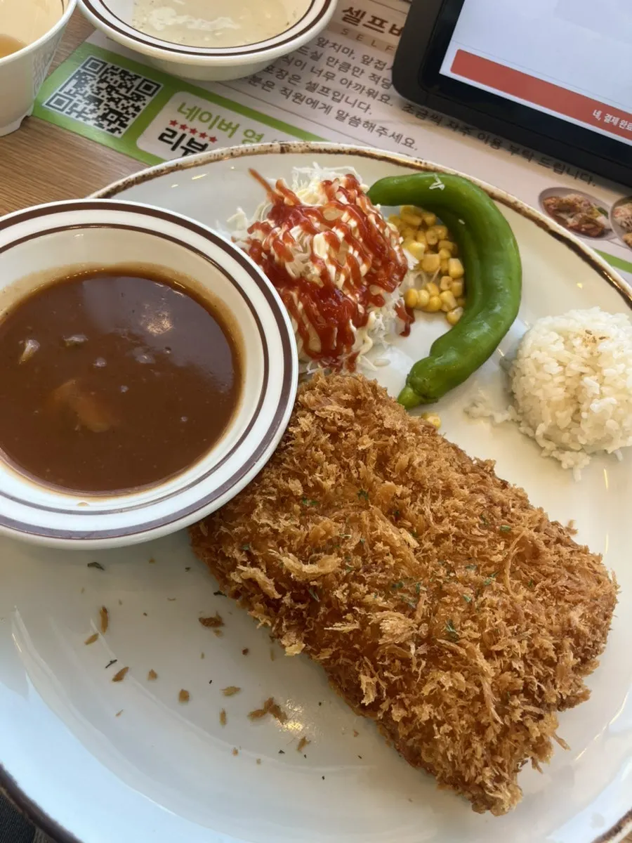 A piece of fish cutlet dipped in tartar sauce