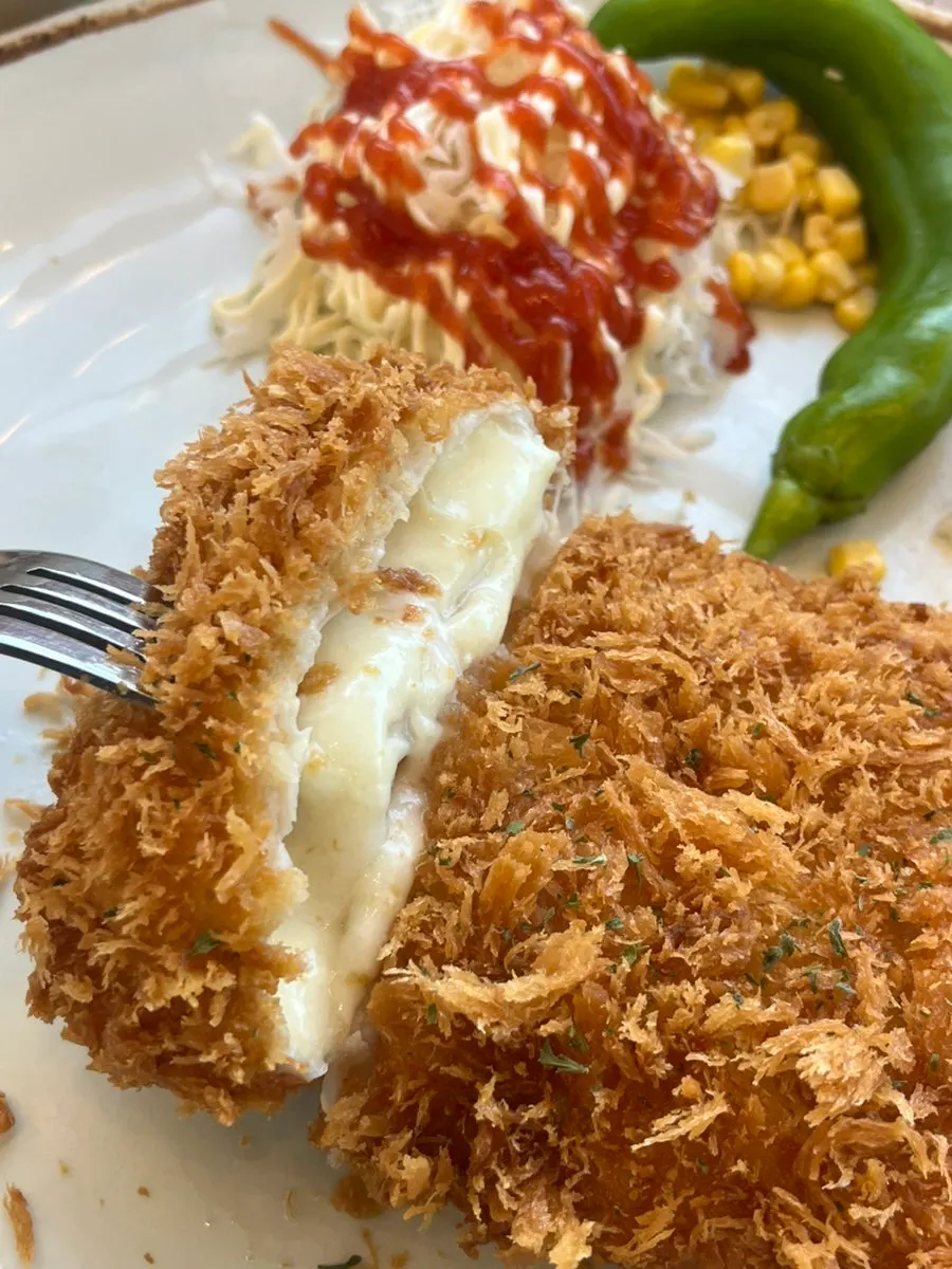 Cross-section of the cheese katsu with cheese overflowing