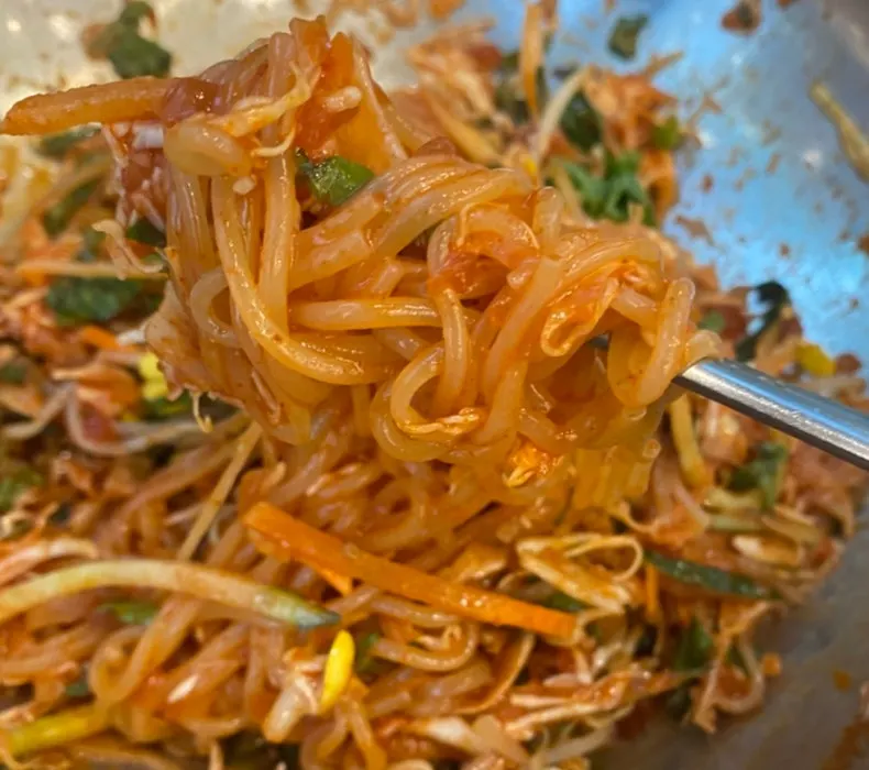 Chopsticks lifting a bite of jjolmyeon