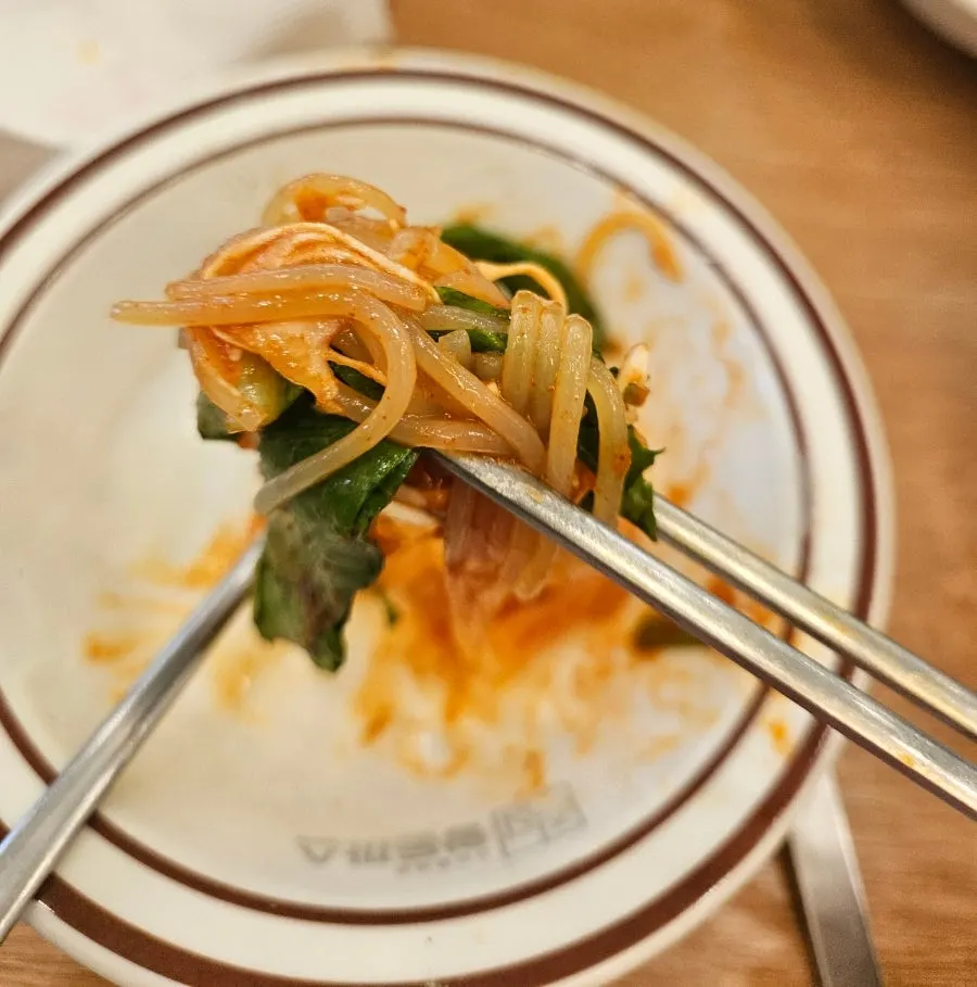 Jjolmyeon noodles lifted with chopsticks