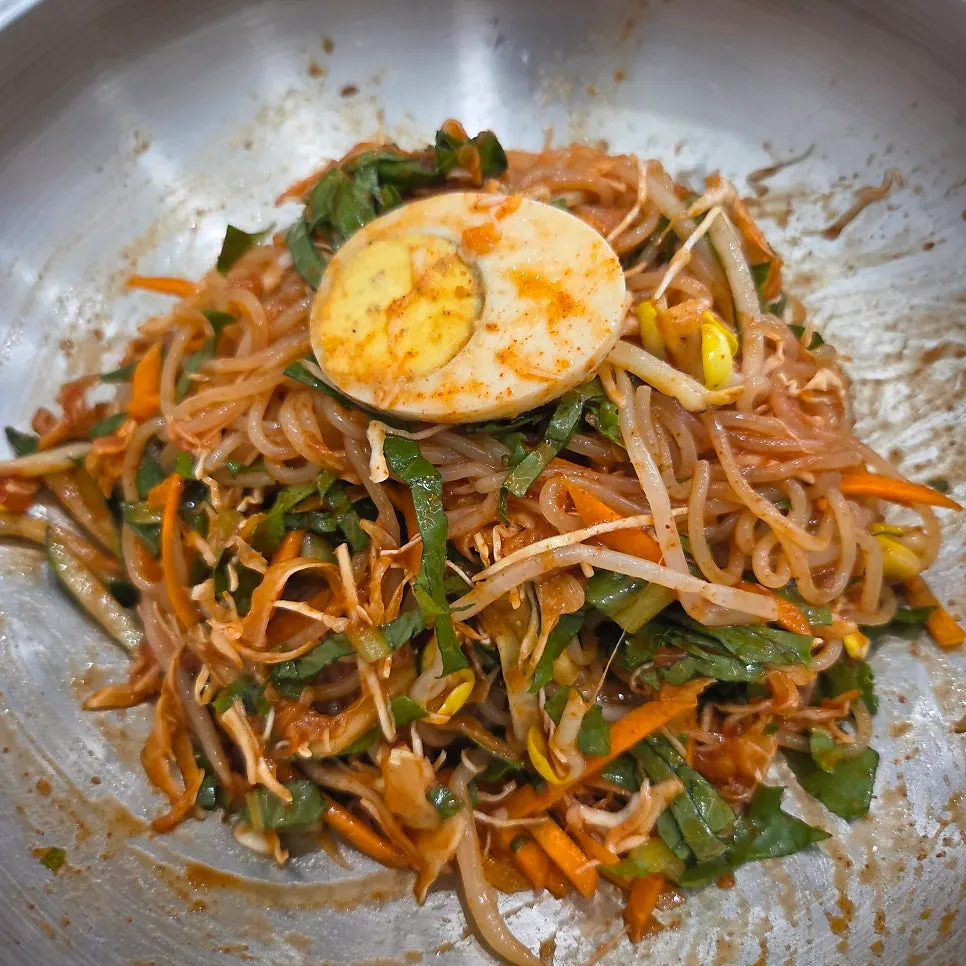 A bowl of jjolmyeon loaded with vegetables