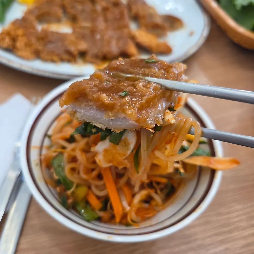 A bite of donkatsu topped with jjolmyeon