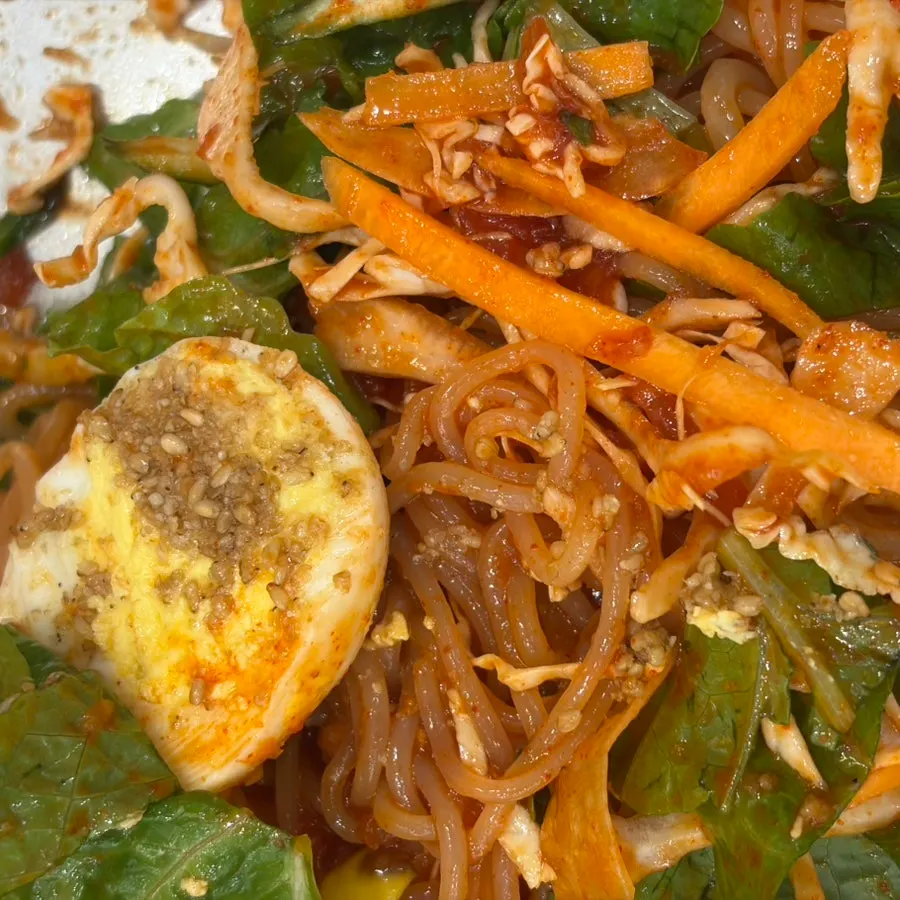 Jjolmyeon topped with seasoning and vegetables