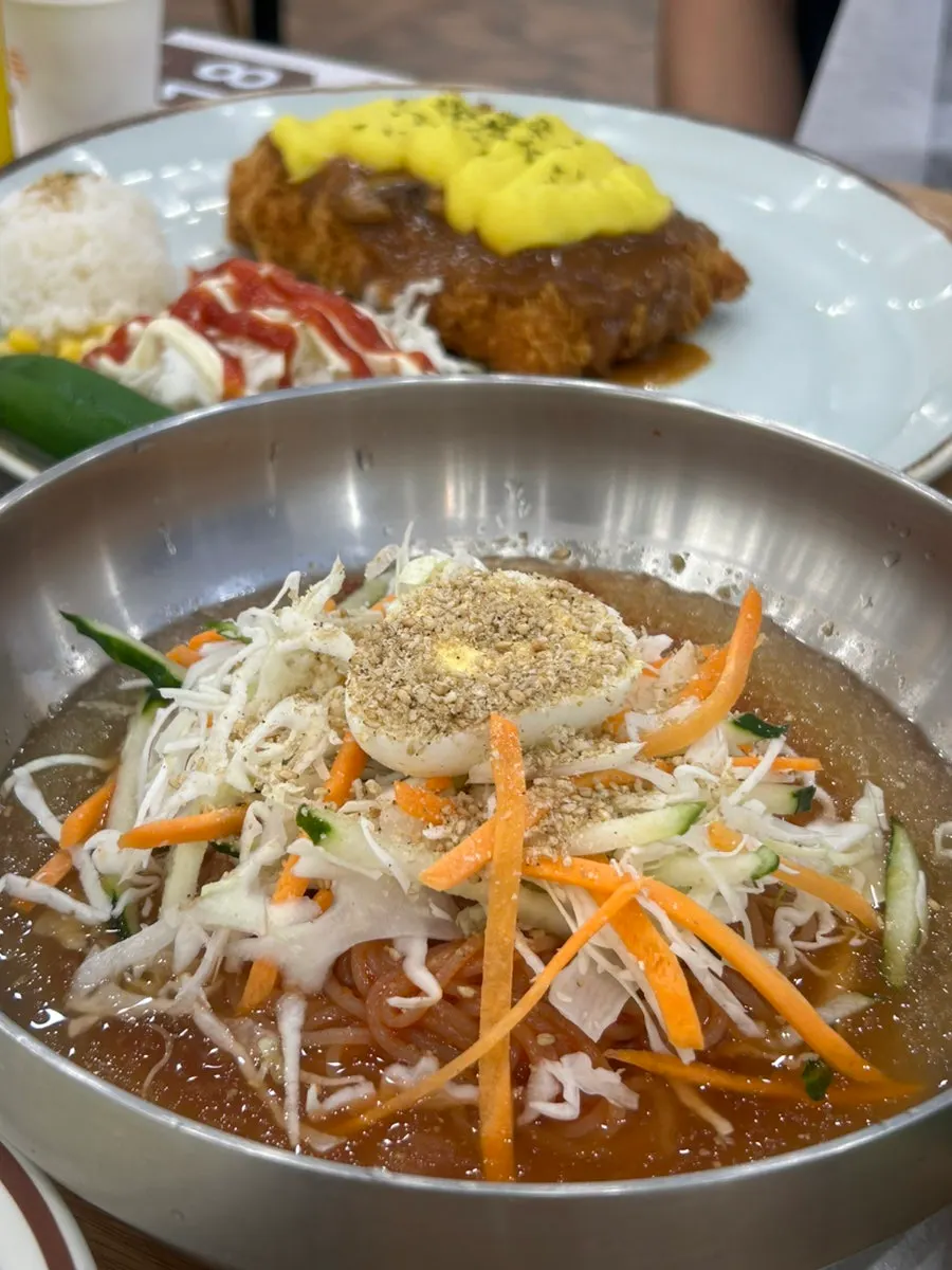 A bowl of cold jjolmyeon in ice-flecked broth