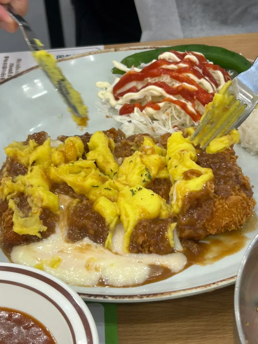 A bite of sweet potato cheese tonkatsu with spicy sauce