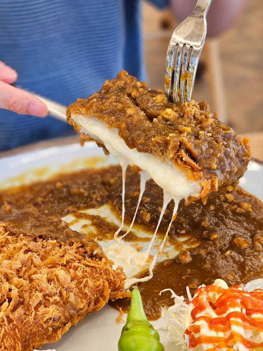 Cheese pouring out as the Cheese Waterfall Curry Donkatsu is cut