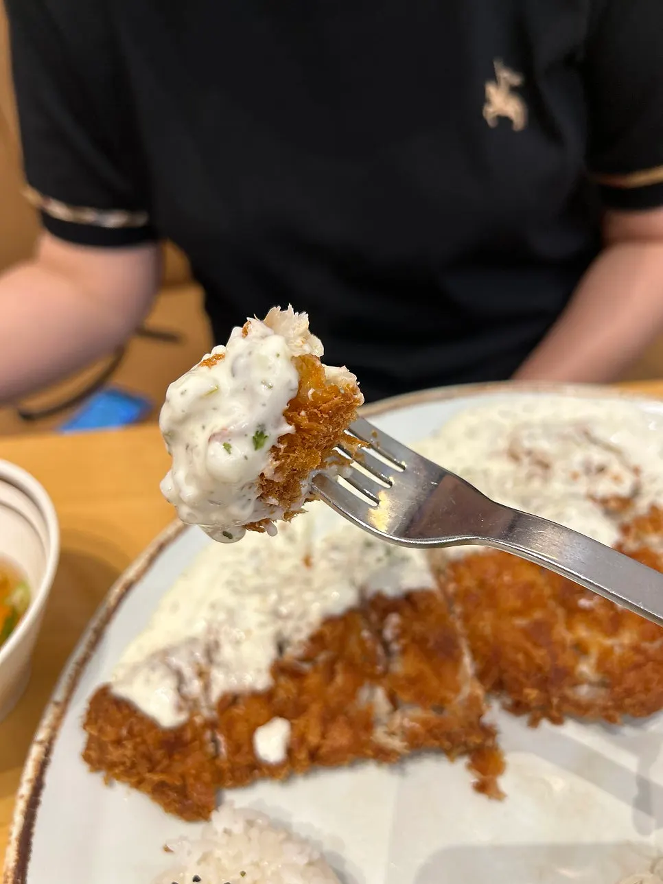 A piece of fish cutlet dipped in tartar sauce