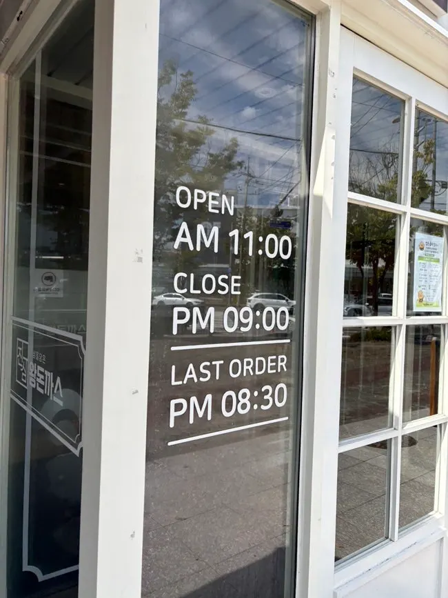Business hours sign at the store entrance