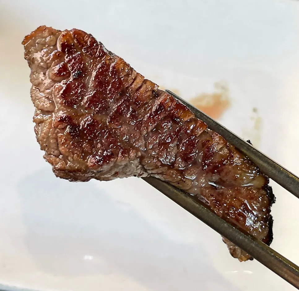 Staff grilling straw-fire seared woo-dae galbi at the table