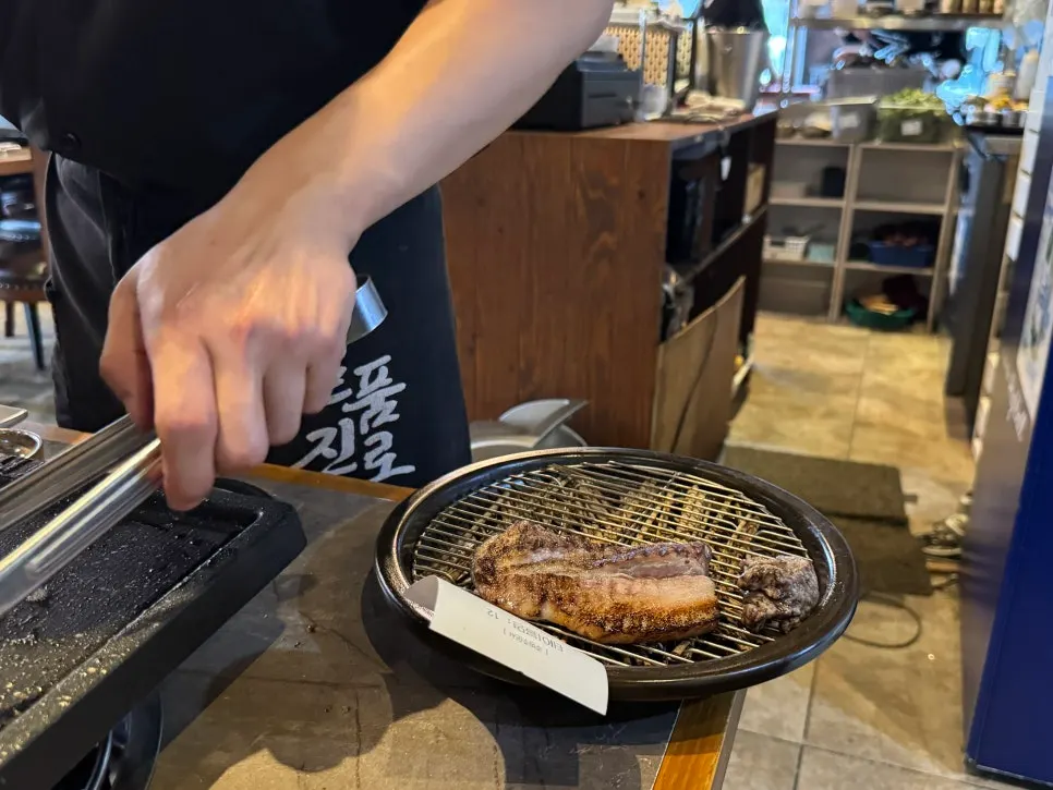 Staff grilling straw-fire pork belly