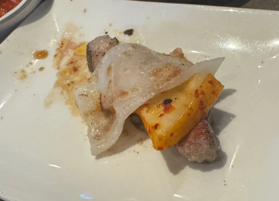 Grilled rice cake topped with pork belly and grilled kimchi