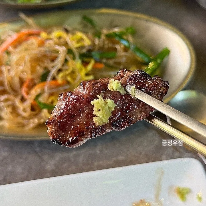 Close-up of a piece of straw-fire scented woodae galbi