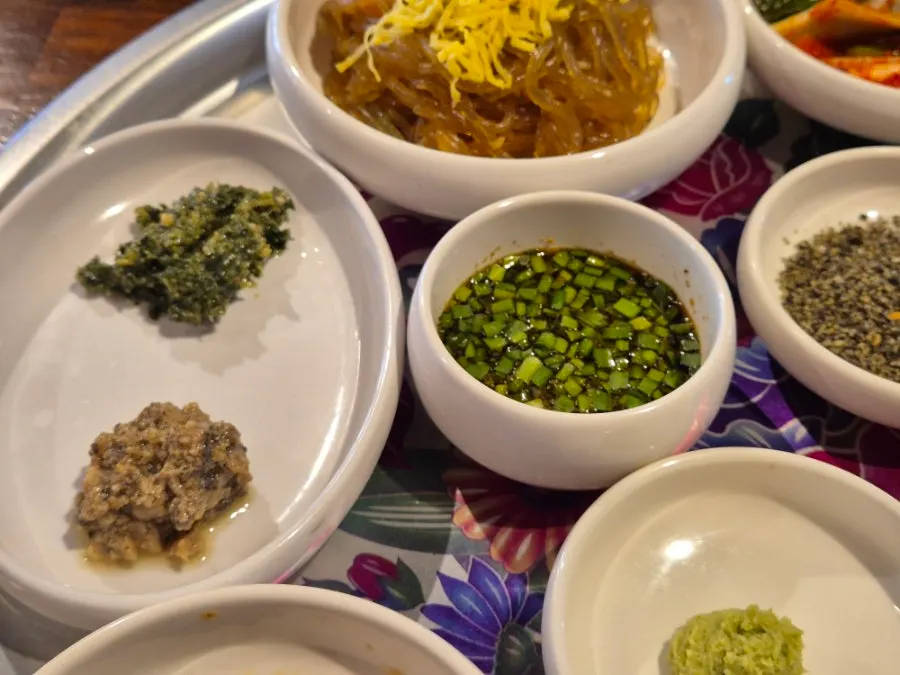 Kimchi and sauces served alongside the meat