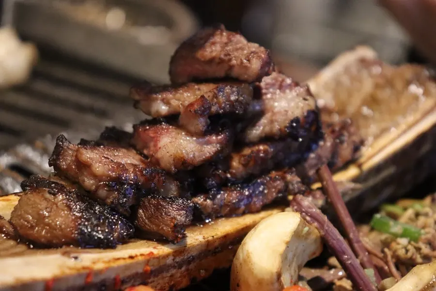 A piece of marinated prime rib picked up with chopsticks