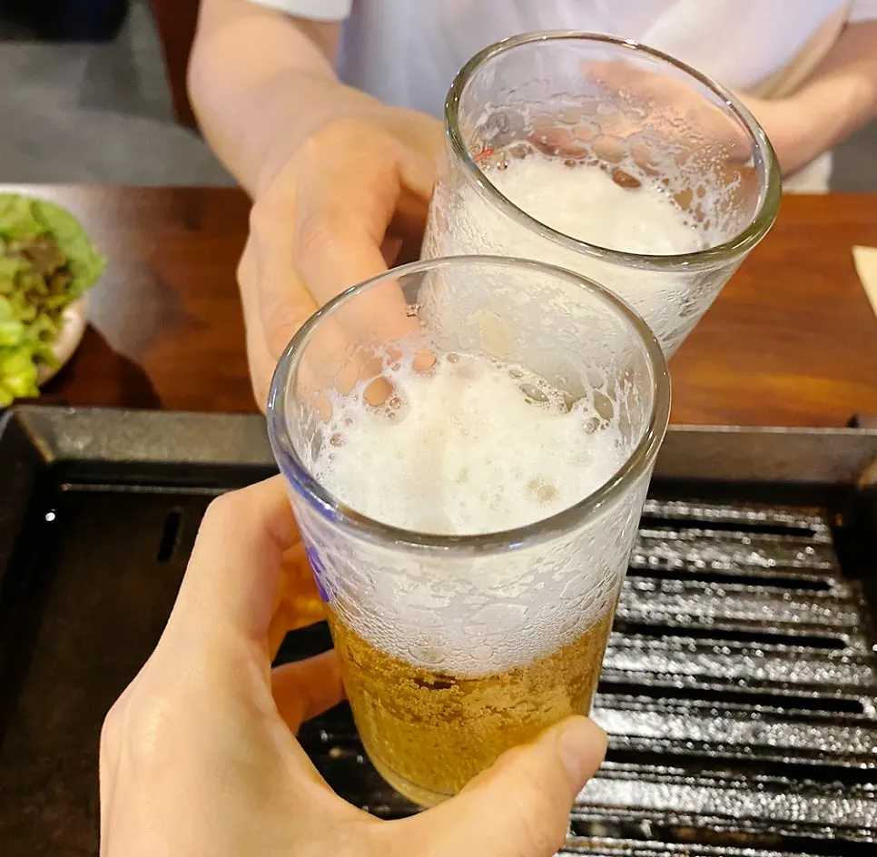 Prime rib, tteok wraps, and beer laid out on the table