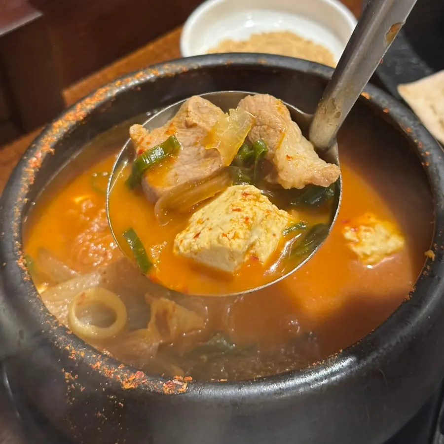 A spoonful of kimchi stew packed with ingredients