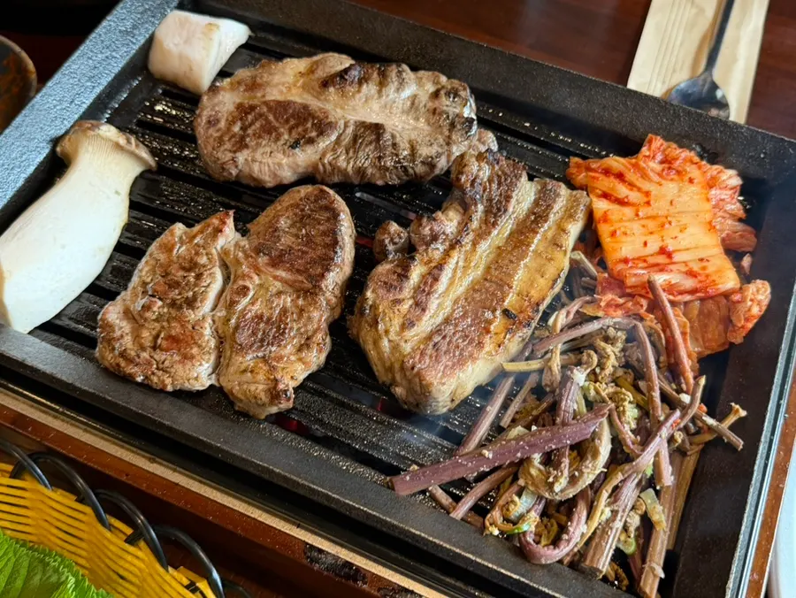 숯불 초벌 후 테이블에서 구워지는 고기