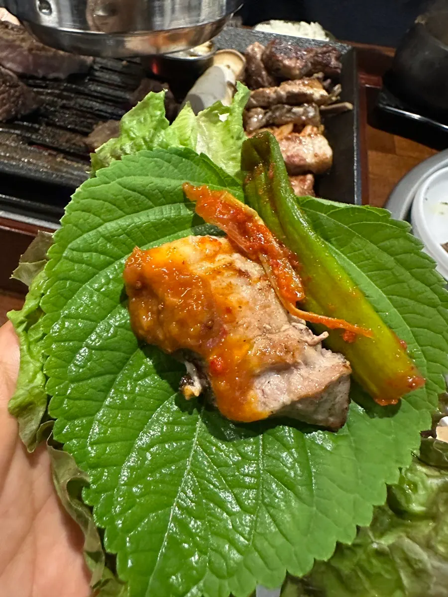 A piece of pork belly dipped in sauce